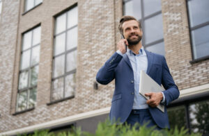 Portrait of an estate agent standing outside his office